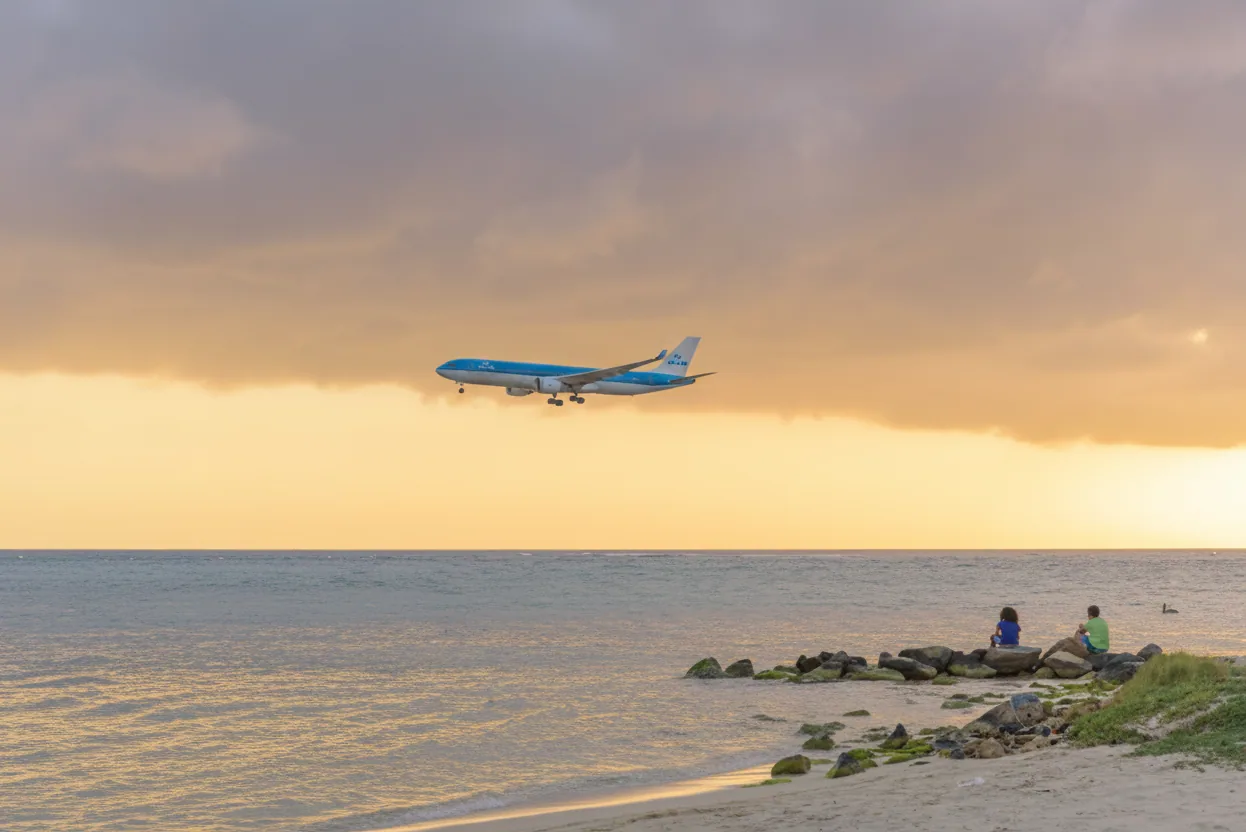 Avión aproximándose a Aruba sobre el mar Caribe al atardecer