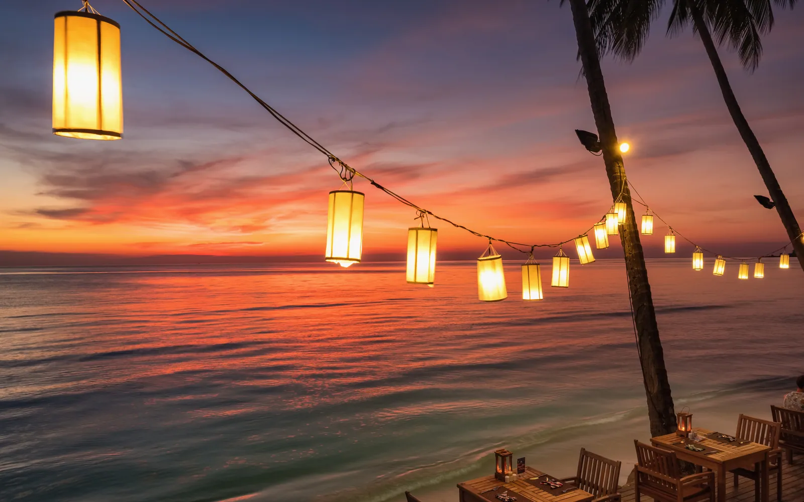 Restaurante junto al mar iluminado durante el atardecer