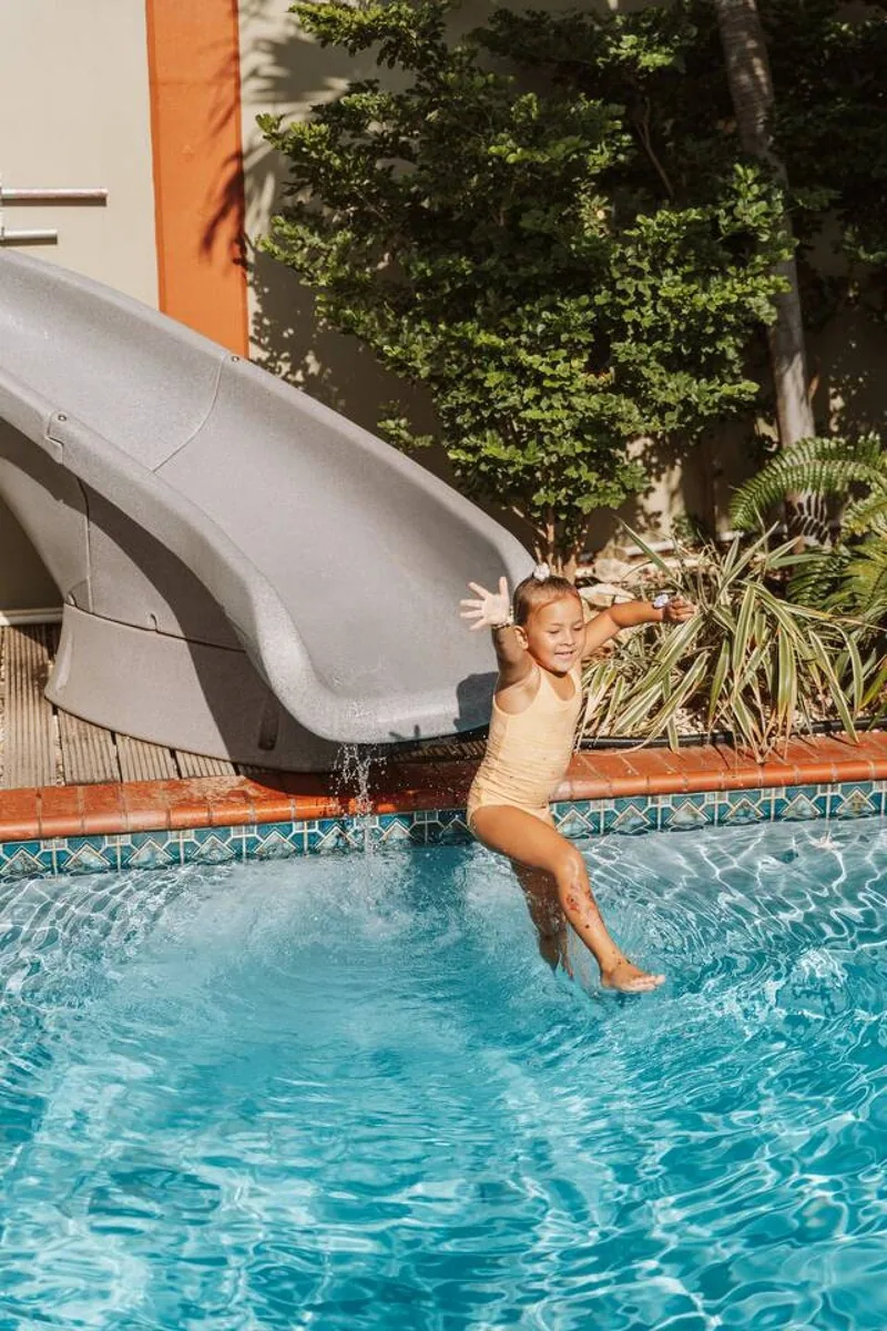 Niña jugando en la piscina con tobogán de Villa Nirvana